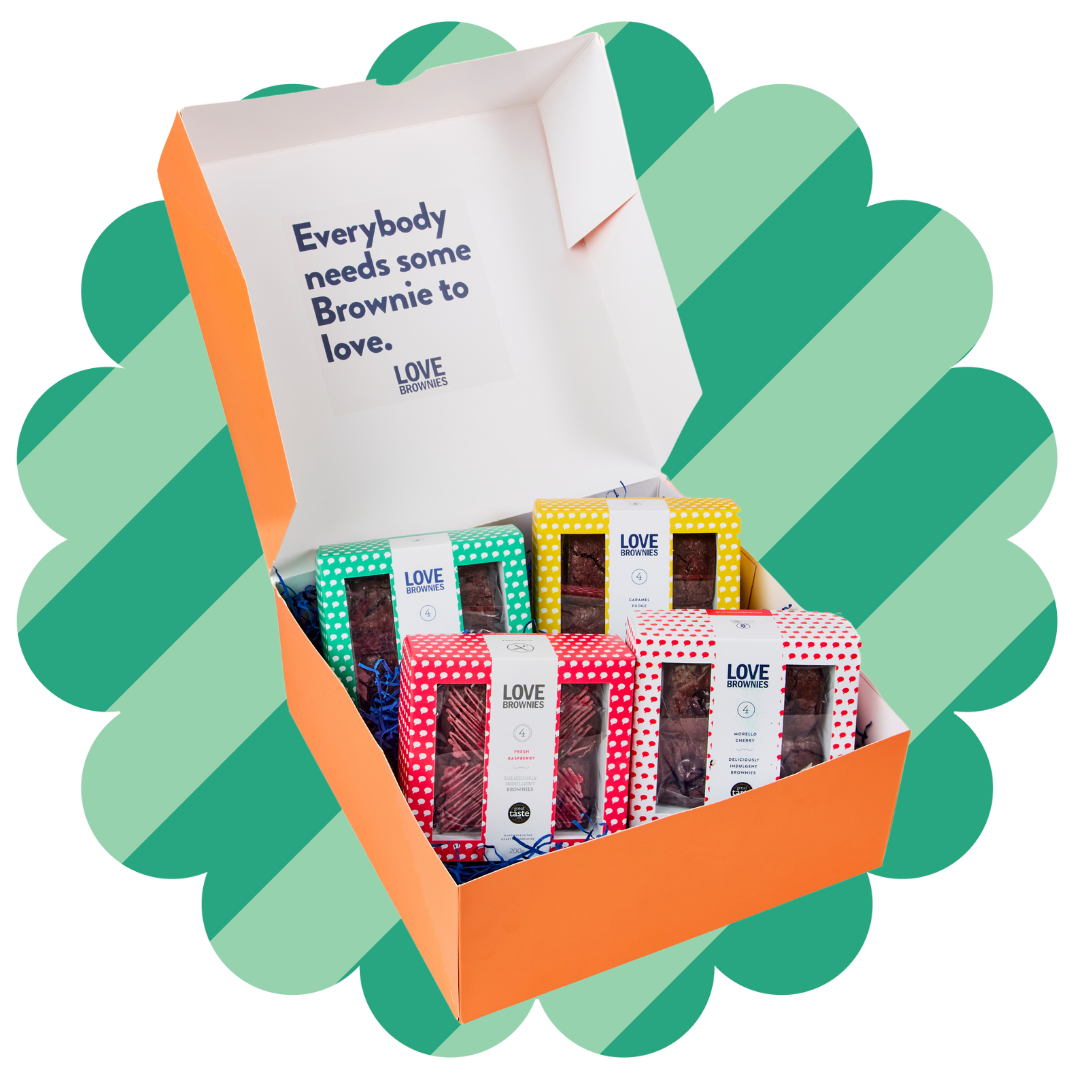 An open gift box labeled 'Everybody needs some Brownie to love' from Love Brownies, displaying various flavoured gift packs of gluten-free, nut-free chocolate brownies.
