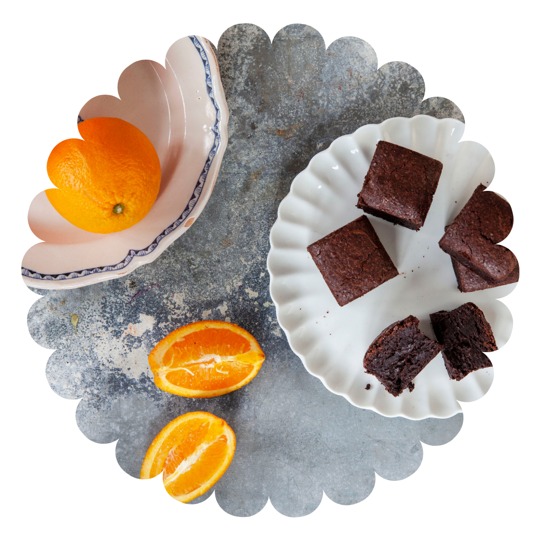 A box of chocolate brownies with different toppings and fillings, presented in a green and white box with Love Brownies on the lid. Salted caramel flavour, raspberry flavour, morello cherry flavour and double chocolate flavour. All gluten free