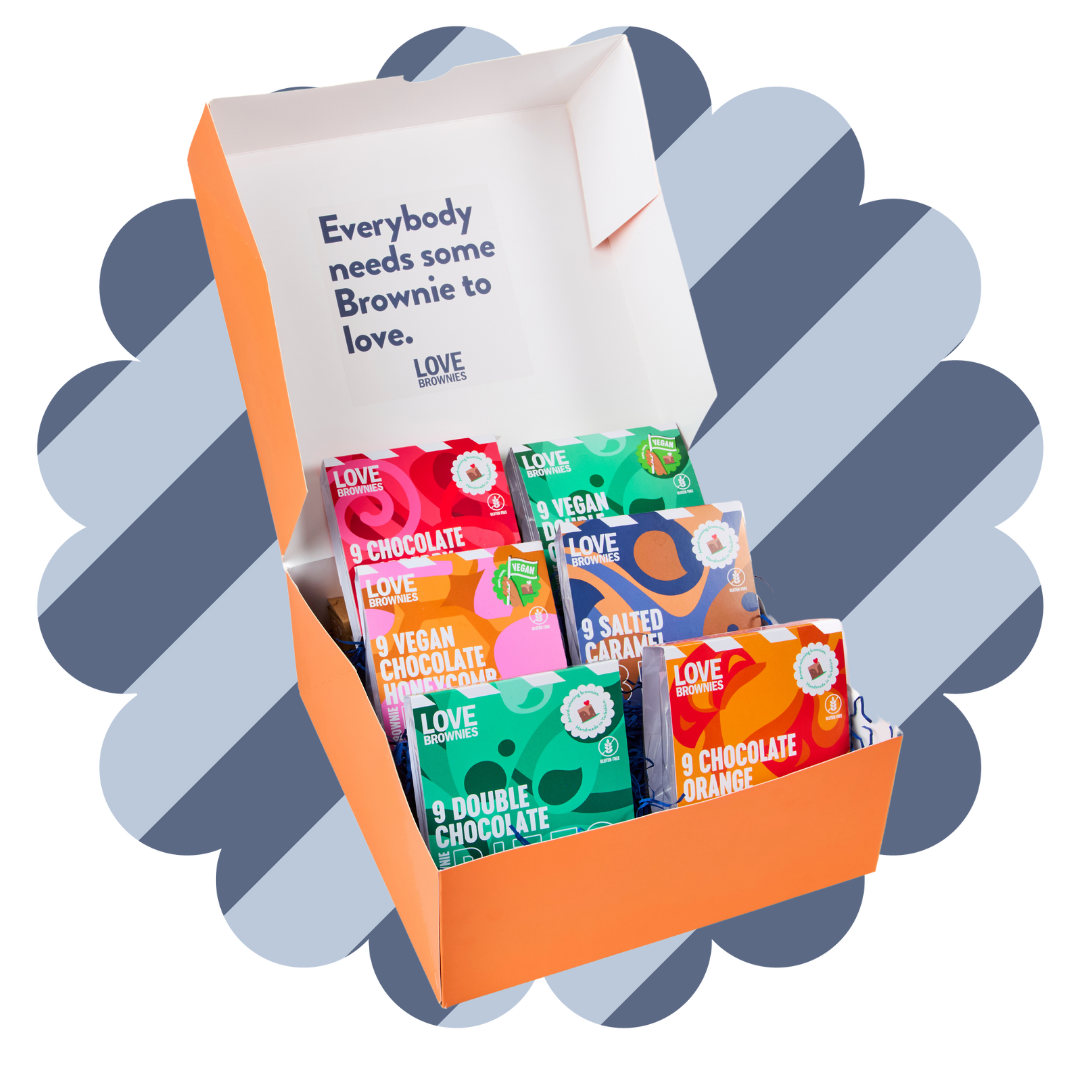 An open gift box displaying various bags of brownie bites with different flavors such as double chocolate, caramel fudge, salted caramel, and more.