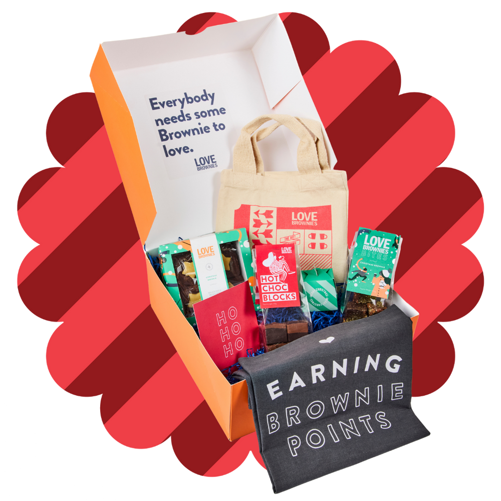 Orange hamper with hot chocolate blocks, grey tea towel, small tote bag, chocolate brownie bites, gift box of gluten-free christmas brownies