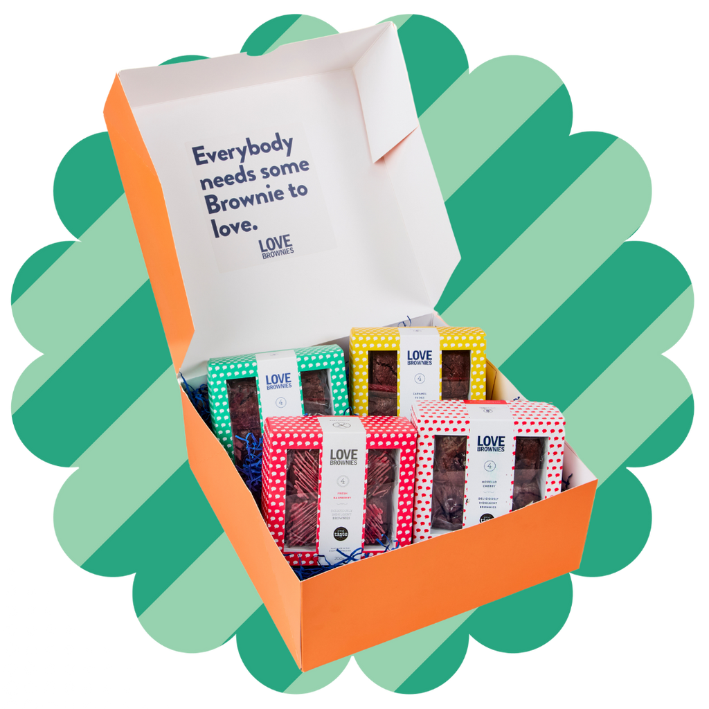 An open gift box labeled 'Everybody needs some Brownie to love' from Love Brownies, displaying various flavoured gift packs of gluten-free, nut-free chocolate brownies.