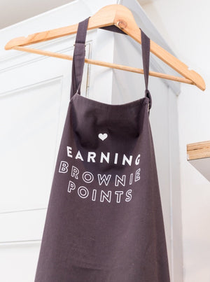 Grey apron with slogan saying Earning Brownie Points
