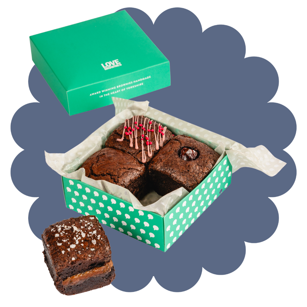 A box of chocolate brownies with different toppings and fillings, presented in a green and white box with Love Brownies on the lid. Salted caramel flavour, raspberry flavour, morello cherry flavour and double chocolate flavour. All gluten free