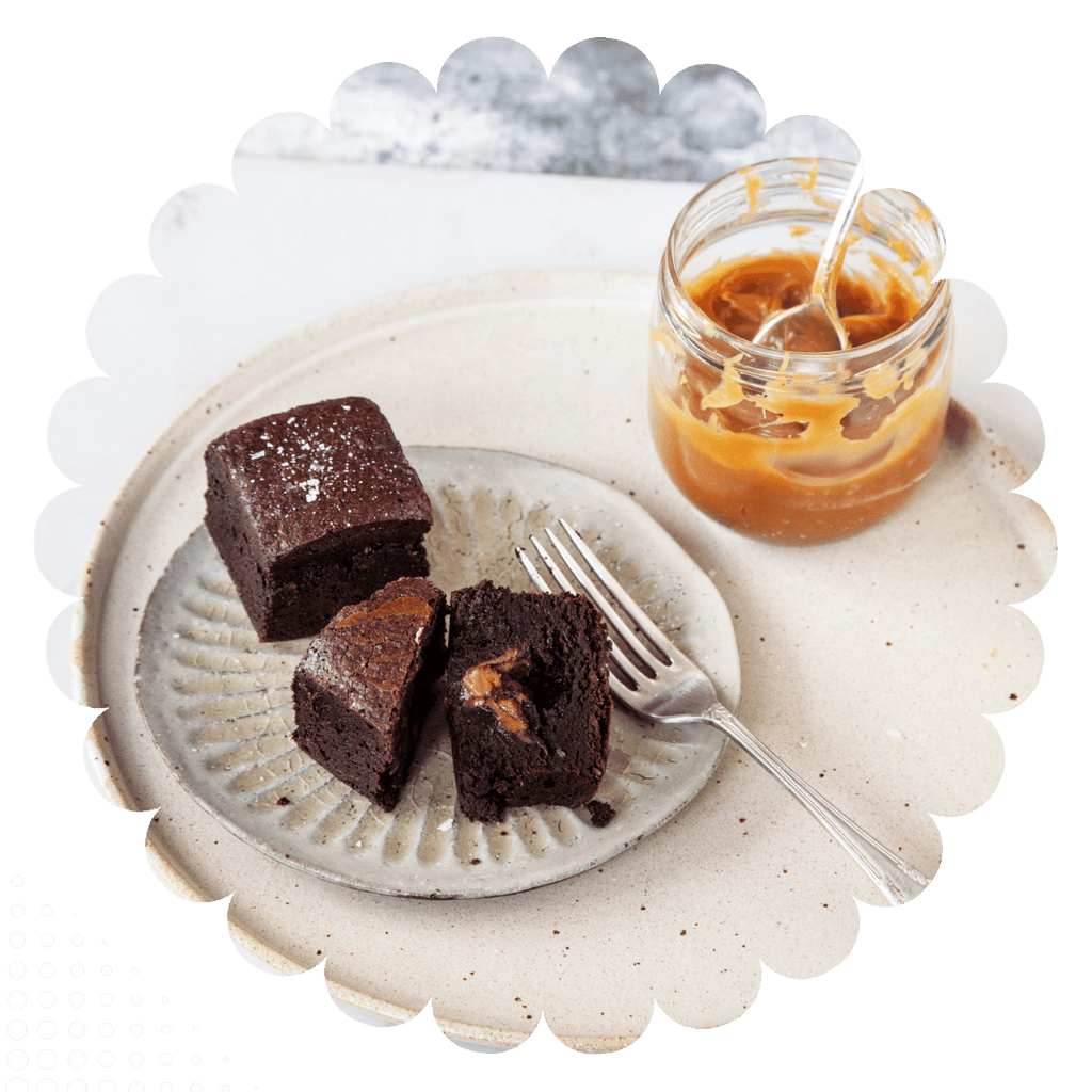 Gooey chocolate brownies with salted caramel centre and pot of caramel.