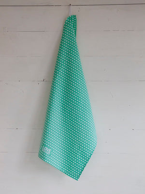green teatowel with speech bubble icons hanging against white wall