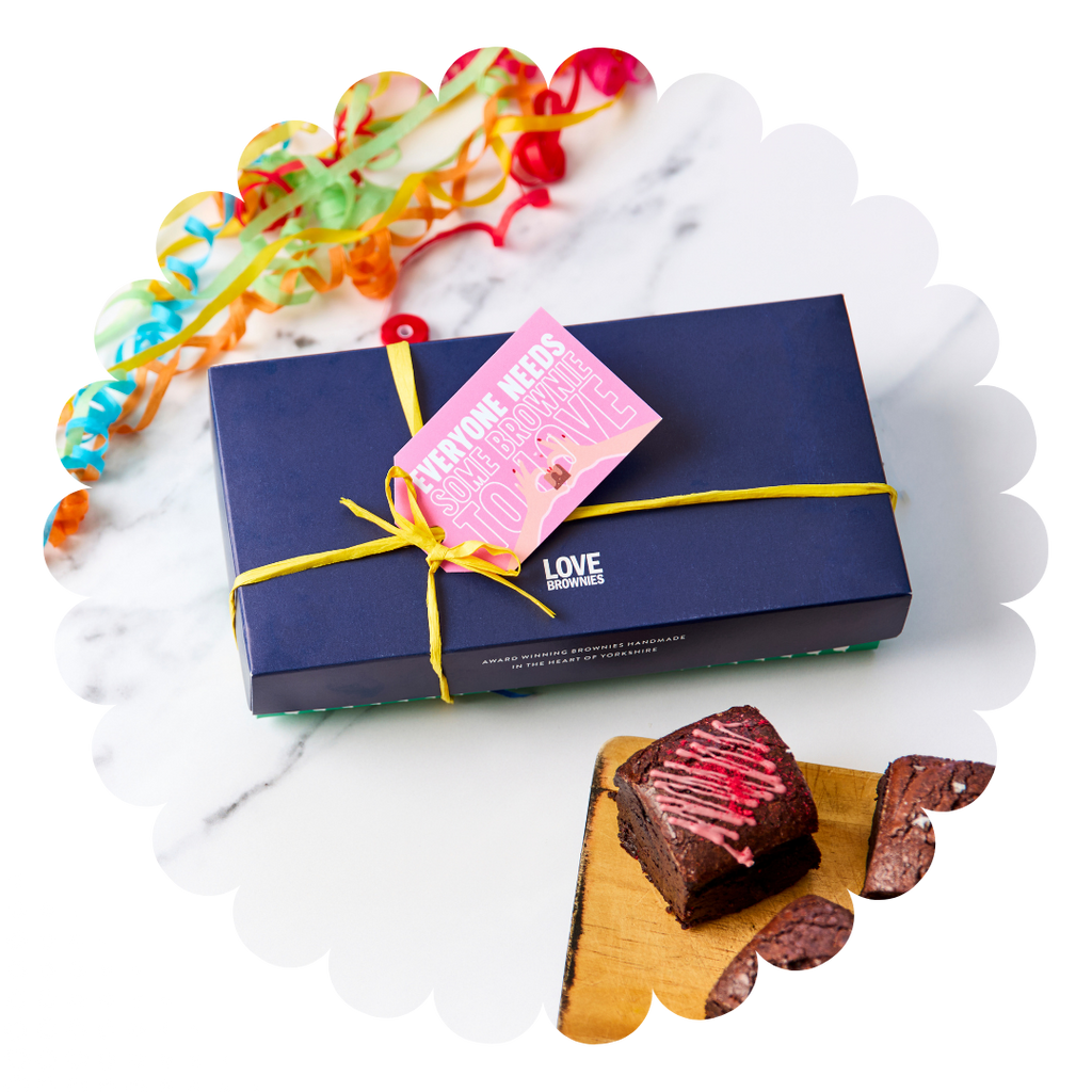 Navy gift box with yellow raffia ribbon and handwritten personalised gift tag and gluten free and nut free raspberry chocolate brownies